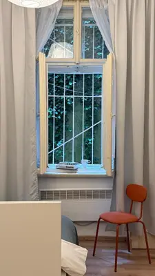 a room with a window with a chair and a table at The Rest Point Prague in Prague
