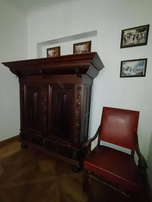 a wooden cabinet and a red chair in a room at Dlouhá Art & Antique Stay in Prague