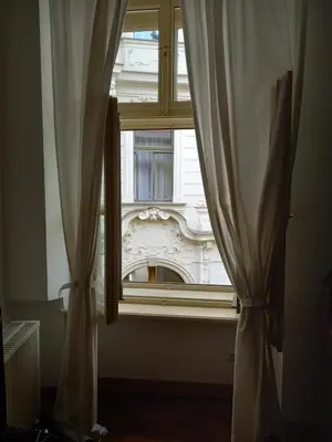 a window with curtains in front of a building at Dlouhá Art & Antique Stay in Prague