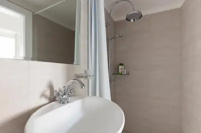 a white sink in a bathroom with a shower at Dlouhá Art & Antique Stay in Prague
