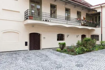 a white building with a balcony and a door at Dlouhá Art & Antique Stay in Prague