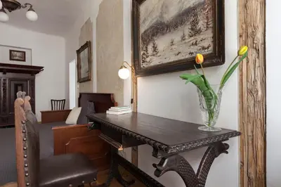 a room with a table with a vase of flowers on it at Dlouhá Art & Antique Stay in Prague
