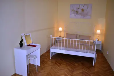 a bedroom with a white bed and a table and a stool at Sunflower 2BDR Flat By Ruterra in Prague