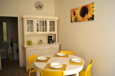 a kitchen with a white table and yellow chairs at Sunflower 2BDR Flat By Ruterra in Prague