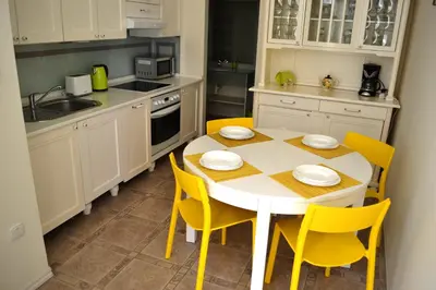 a kitchen with a white table and yellow chairs at Sunflower 2BDR Flat By Ruterra in Prague
