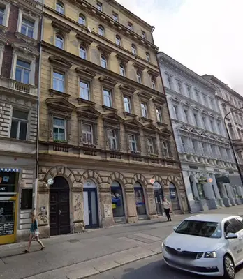 a white car parked in front of a large building at Sunflower 2BDR Flat By Ruterra in Prague