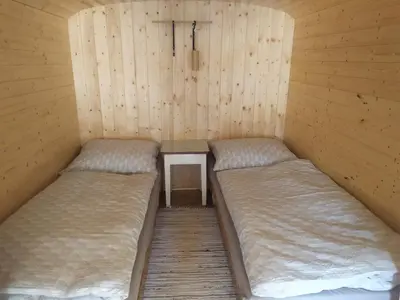 a room with two beds and a table in it at Maringotka Waldeck in Ohrazenice