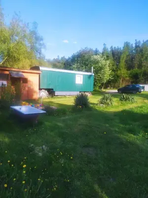 a yard with a green building and a house at Maringotka Waldeck in Ohrazenice