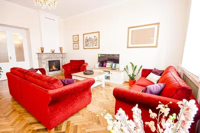 a living room with two red couches and a fireplace at Florentinum Residence Prague Old Town in Prague