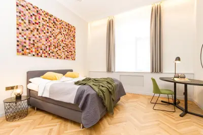 a bedroom with a bed and a table with a chair at Florentinum Residence Prague Old Town in Prague