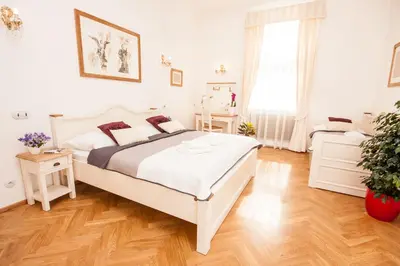 a white bedroom with a bed and a window at Florentinum Residence Prague Old Town in Prague