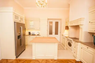 a kitchen with white cabinets and a wooden counter top at Florentinum Residence Prague Old Town in Prague