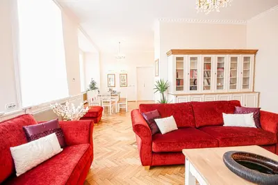 a living room with two red couches and a table at Florentinum Residence Prague Old Town in Prague