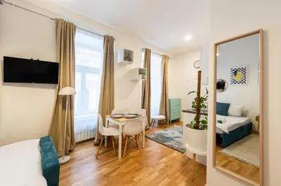 a living room with a bed and a table in a room at Peter's Square Residence in Prague