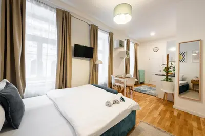 a bedroom with a bed and a living room at Peter's Square Residence in Prague