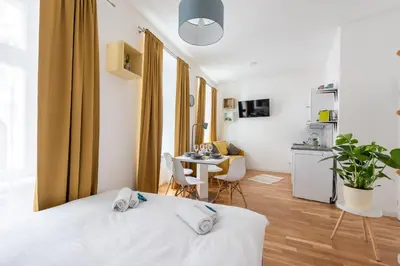 a bedroom with a bed and a table with chairs at Peter's Square Residence in Prague