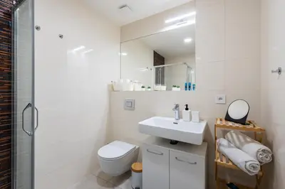 a white bathroom with a toilet and a sink at Peter's Square Residence in Prague