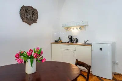 a kitchen with a table with a vase of flowers on it at Nerudova Lesser Town Apartments in Prague