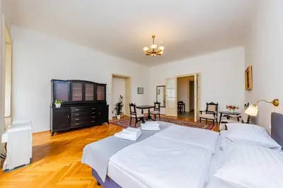 a large bedroom with a bed and a dining room at Nerudova Lesser Town Apartments in Prague