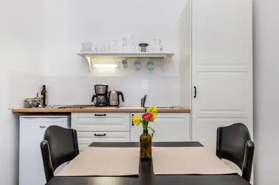a kitchen with a table with a vase of flowers at Nerudova Lesser Town Apartments in Prague