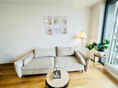 a living room with a couch and a table at New building New apartment at Andel Metro Station in Prague
