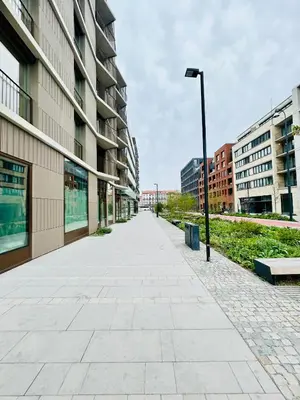 an empty sidewalk in front of a building at New building New apartment at Andel Metro Station in Prague
