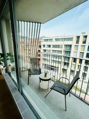 a balcony with two chairs and a table and a building at New building New apartment at Andel Metro Station in Prague