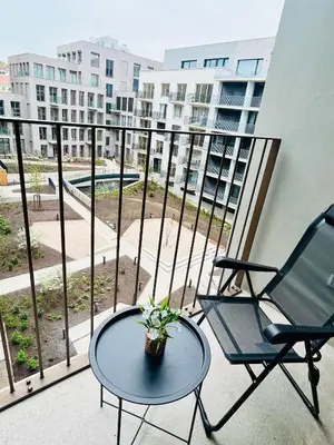 a balcony with two chairs and a table on a balcony at New building New apartment at Andel Metro Station in Prague