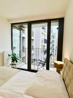 a bedroom with a bed and a view of a balcony at New building New apartment at Andel Metro Station in Prague