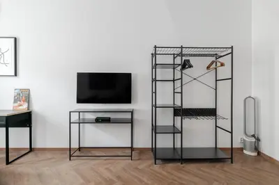 a room with a tv and a black book shelf at Meloun City Center Residence in Prague