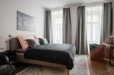 a bedroom with a bed in a room with windows at Meloun City Center Residence in Prague