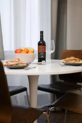 a table with a bottle of wine and a bowl of fruit at Meloun City Center Residence in Prague