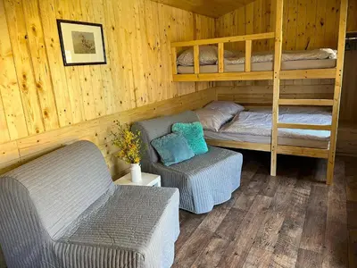 a room with a bed and a couch and bunk beds at Sádky Lety in Lety