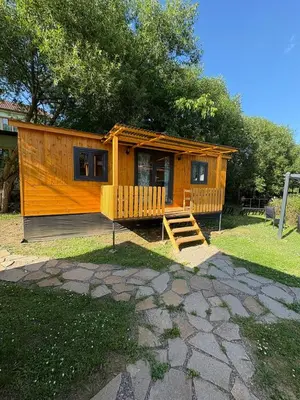 a small wooden cabin with a staircase in a yard at Sádky Lety in Lety