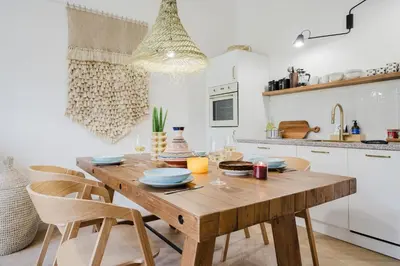 a kitchen with a wooden table and chairs at Prague Days - Boho One-bedroom Apartment with Netflix in Vinohrady in Prague