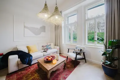 a living room with a white couch and a table at Prague Days - Boho One-bedroom Apartment with Netflix in Vinohrady in Prague