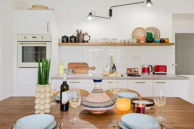 a kitchen with a wooden table with wine glasses at Prague Days - Boho One-bedroom Apartment with Netflix in Vinohrady in Prague