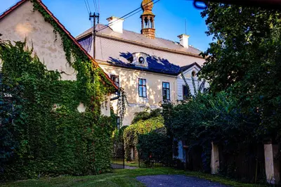 a large white house with a tower on top of it at Statek Adámek in Borotice