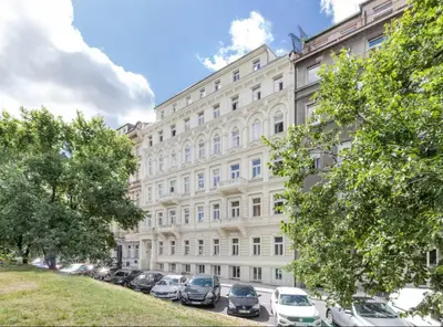a large white building with cars parked in front of it at Modern Flat in Iconic Location in Prague