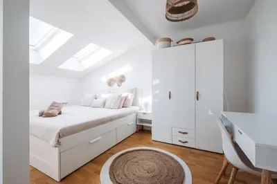 a white bedroom with a bed and a desk at Modern Flat in Iconic Location in Prague