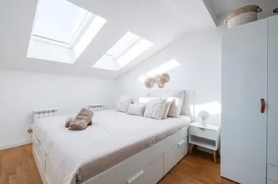 a white bedroom with a white bed and skylights at Modern Flat in Iconic Location in Prague