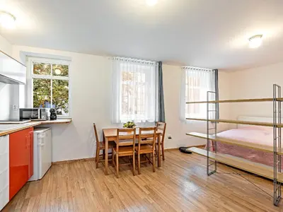 a kitchen and dining room with a table and a bunk bed at Cosy Studio in Vysehrad in Prague
