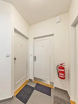 a hallway with two white doors and a fire extinguisher at Cosy Studio in Vysehrad in Prague
