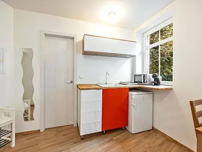 a kitchen with a red and white counter top at Cosy Studio in Vysehrad in Prague