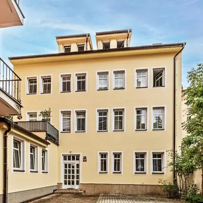 a large yellow building with white windows at Cosy Studio in Vysehrad in Prague