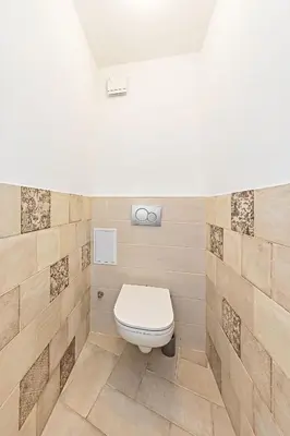 a bathroom with a toilet in a tiled wall at Cosy Studio in Vysehrad in Prague