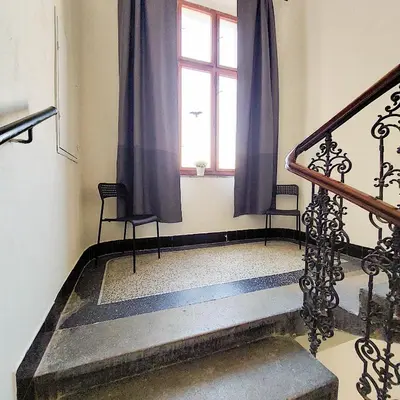 a room with a staircase with a window and two chairs at Pokoj A2 v Praze in Prague