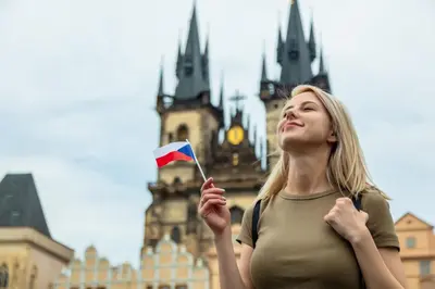 a woman holding a flag in front of a building at Pokoj A2 v Praze in Prague