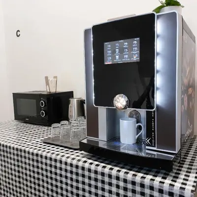 a coffeemaker on a table with a black and white checkered table at Pokoj A2 v Praze in Prague