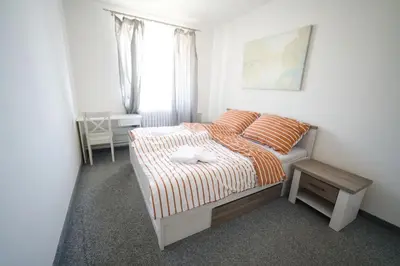 a bedroom with a bed and a table and a window at Penzion a restaurace U Jágrů in Kladno